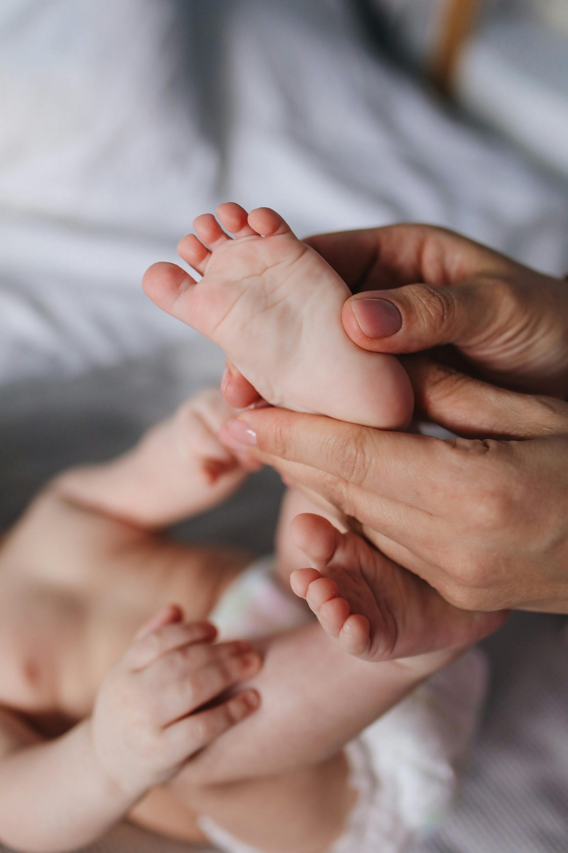 réflexologie bébé doula entrain de faire la réflexologie sur les pieds d'un bébé