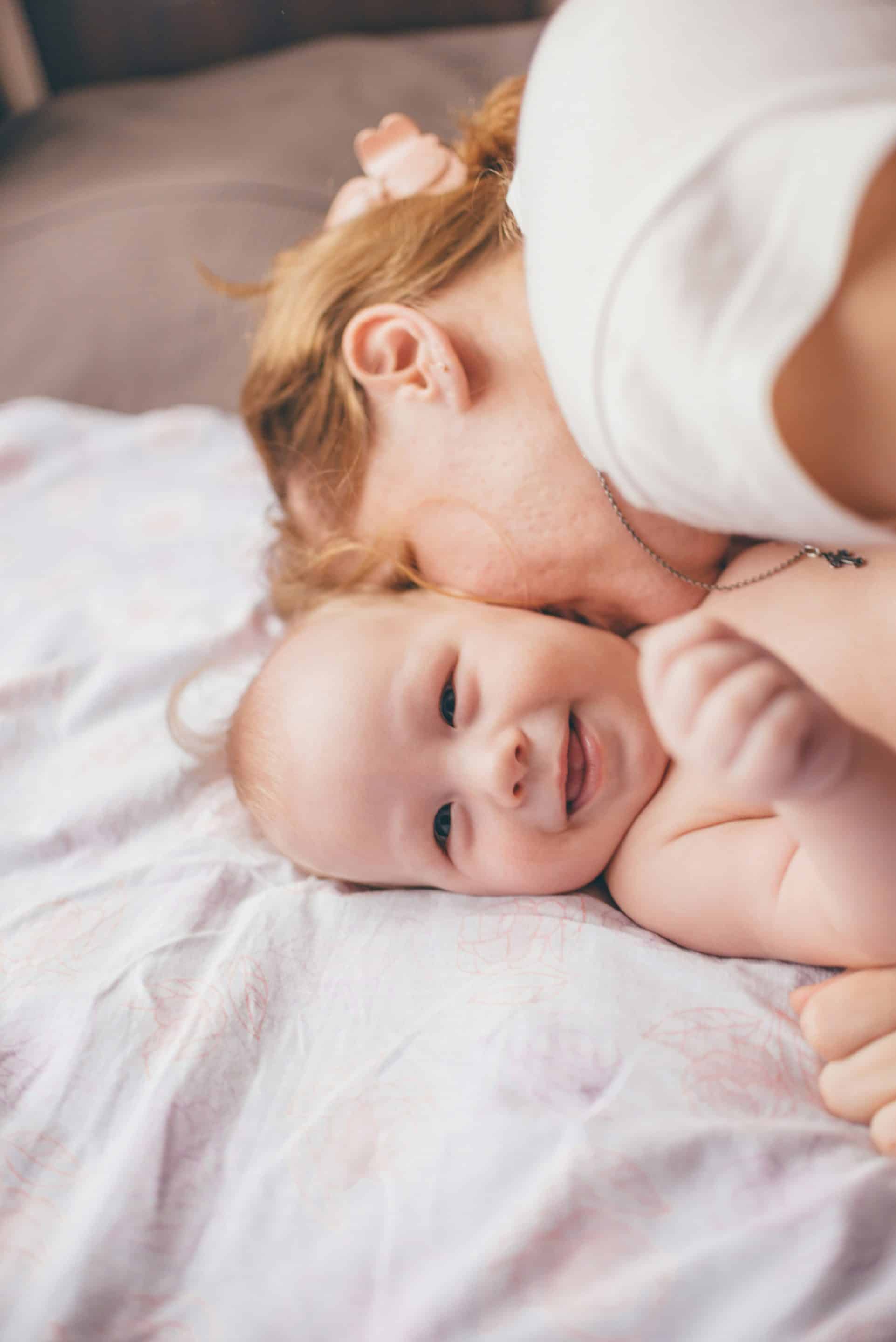 accompagnement doula maman entrain de faire un bisou à son bébé allongé