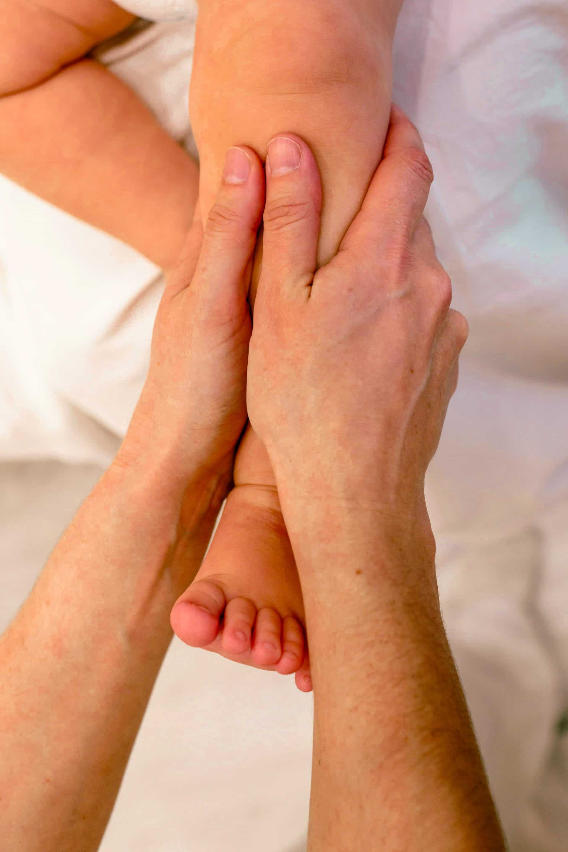 massage bébé jambes- accompagnante périnatale massant la jambre d'un bébé